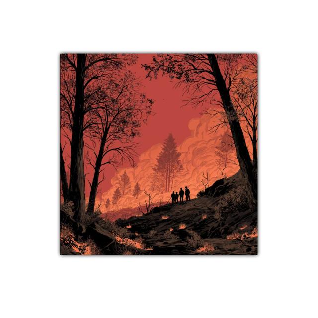 Atardecer intenso con siluetas entre árboles en llamas