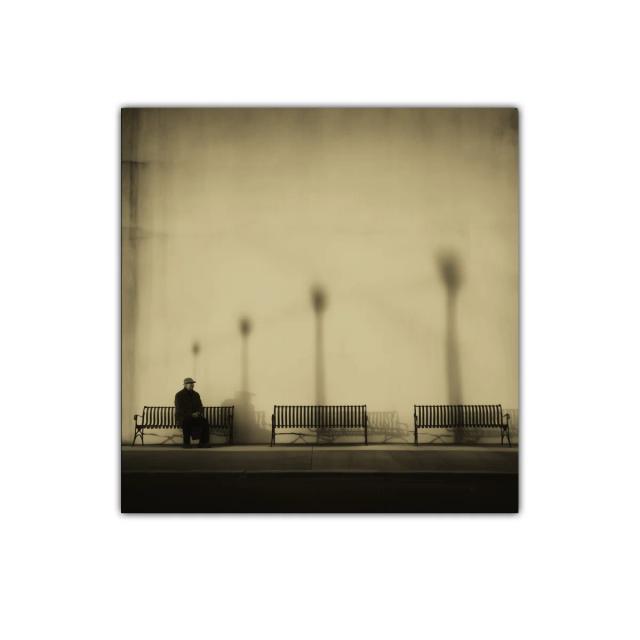 Paisaje urbano melancólico con bancos y figura solitaria