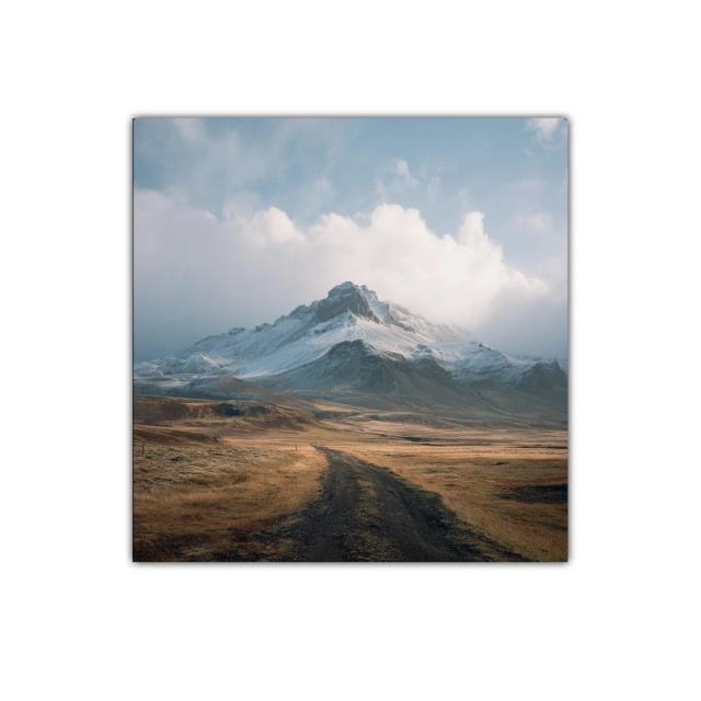 Paisaje montañoso con cielo nublado y camino terroso